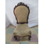 A Victorian upholstered bedroom chair with carved decoration.