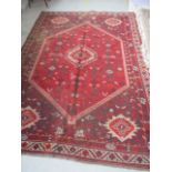 A large handwoven red ground rug