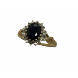 A 9 ct gold ring with central sapphire and diamond surround