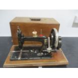 A vintage hand sewing machine in inlaid case