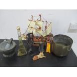 A collection of various items including a model of the Mayflower ship, a mortar and pestle, a bottle