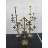 A pair of ecclesiastical style brass candelabra, along with one other similar