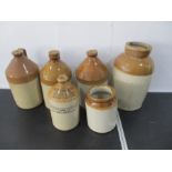 A collection of four stoneware cider flagons, along with two stoneware pots and metal cash box