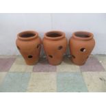 Three terracotta strawberry pots