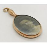 A 9ct gold pendant with photograph to one side and mirror to reverse.
