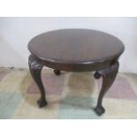A vintage circular coffee table on claw and ball feet