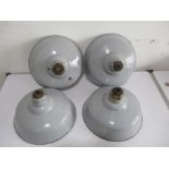 A set of four industrial enamelled light shades