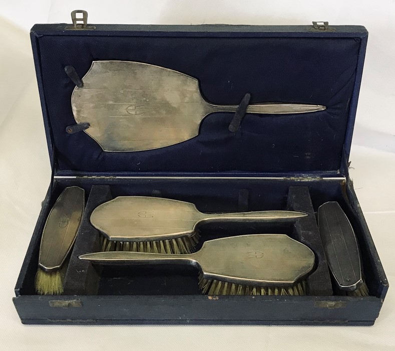 A cased hallmarked silver dressing table set. A/F