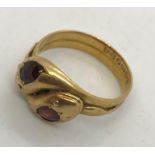 An 18ct gold double head snake ring set with garnets. Total weight 7g