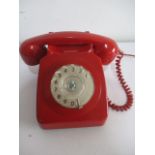 A vintage red rotary telephone