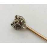 An unmarked gold stick pin, the top in the form of a fox head set with diamond and ruby eyes.