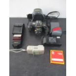 A Canon T-70 camera along with two others and accessories