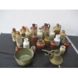 A collection of various stoneware bottles, brass saucepan, bell etc.
