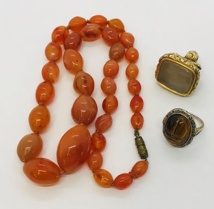 A hard stone necklace, Victorian gilt fob and a silver tigers eye ring.