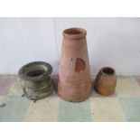 Two terracotta chimneys, along with another garden planter