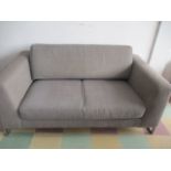 A modern grey sofa with chromed legs