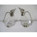 A pair of modern wine decanters in the form of ducks with glass bodies and silver plated mounts,