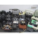 A collection of vintage cameras, lens, flashes, binoculars etc, including Nikon, Canon, Pentax,