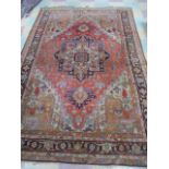 A red ground hand woven rug with diamond shaped medallion