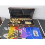 A cased Blessing Elkhart Saxophone, along with a selection of saxophone sheet music books