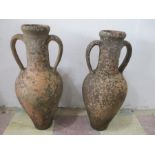 A near pair of weathered terracotta urns, approx 63 cm height