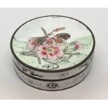 An enamelled patch box decorated with flowers to the top and underside and two gentleman on the