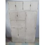 A mid century kitchen unit of six cupboards of varying sizes- top section removable