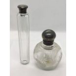 A silver topped scent bottle along with one other