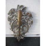 A brass door knocker in the form of a hand holding a hammer- possibly Masonic