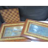 Two landscape prints in ornate frames along with a wooden chess board
