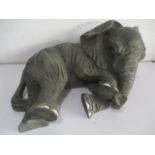 A large resin figure of a resting elephant, approx. 56cm width