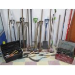 A collection of various garden tools including spades, rakes, shears, hoes etc
