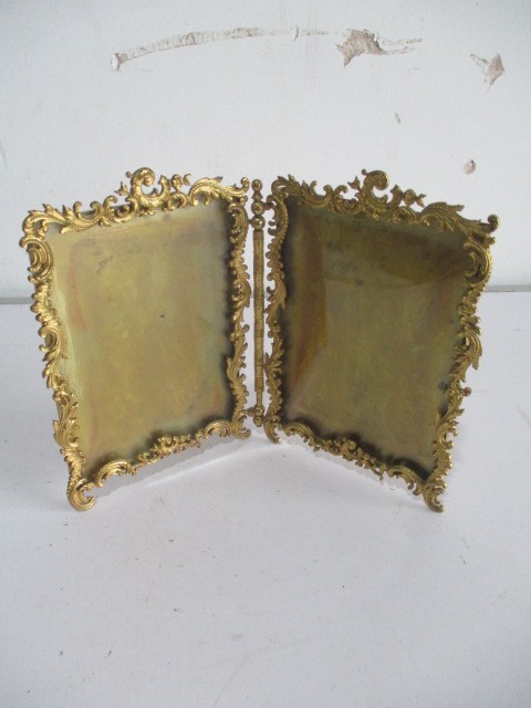 An ornate brass double photo frame