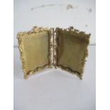 An ornate brass double photo frame