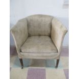 An Edwardian tub chair on tapering legs