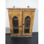 A hanging wall cupboard with wrought iron decoration