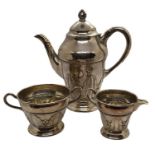 An Arts and Crafts silver plated coffee pot, sugar bowl, and cream jug with hammered detailing,
