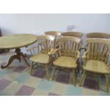 A round pine dining table on tripod base along with a set of 6 beech carvers