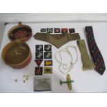 An assortment of interesting military items including a collar box, badges, a chrome cigarette case,