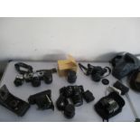 A collection of various cameras and lenses including Olympus, Minolta, Sigma and Praktica along