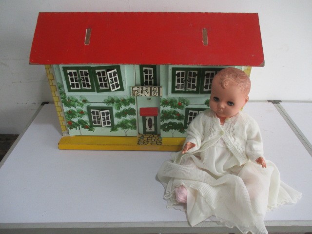 A vintage dolls house with a selection of furniture included, along with a baby doll