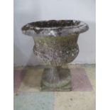 A well weathered garden pot on stand