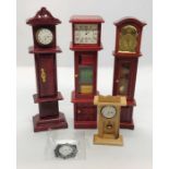 Three doll house long case clocks along with a mantle clock etc