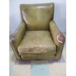 A leather club chair, leather distressed in places