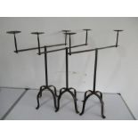 A set of three wrought iron two branch candelabra