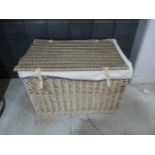 A large wicker laundry basket with front fastenings