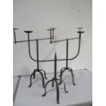 A pair of wrought iron two branch candelabra along with one similar with central spike