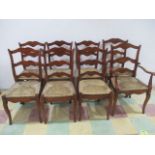 A set of eight rush seated French farmhouse style cherrywood ladder back chairs