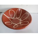 A glazed terracotta creamer/bowl with slipware decoration, 50cm diameter