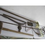 A collection of vintage tools including a shovel, sledgehammer etc